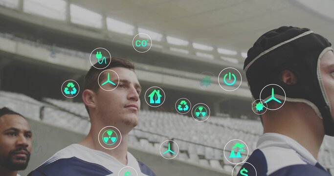 Standing four rugby players wearing navy jerseys and padded scrum cap in stadium, showing AR icons