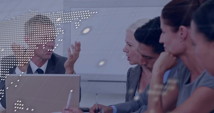 Speaking man in suit addressing team in suits in office, with laptop and dotted world-map overlay