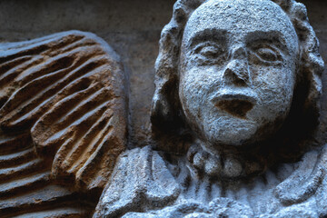 Fototapeta premium Angel of death sculpture with melancholic face, conveying grief, memory, and the quiet presence of loss in a dramatic light.