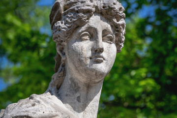Obraz premium Stone goddess Aphrodite expressing grace, softness, and romantic beauty in a peaceful green environment.
