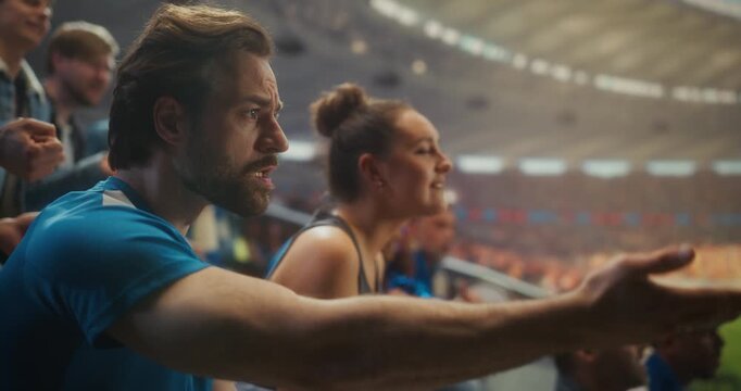 Soccer Team Lost: Supporters in Blue Sit Frozen in a Open Stadium After Defeat, as Man Stares in Disbelief and a Young Woman Buries Her Face in Frustration and Despair. Slow Motion