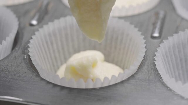 Thick cake batter poured into cupcake liner showing texture in macro close up