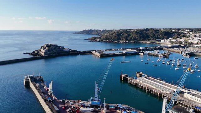 St Peter Port Guernsey reveal drone footage of Ferry berth and docks Castle Cornet and the harbour with views across to St Martin with stunning deep blue calm sea in late afternoon sun