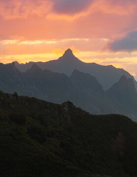 Aerial view of dramatic peaks pierce the sky as the sun sets, casting a warm glow on the rugged landscape, Santa Cruz de Tenerife, Canarias, Spain.