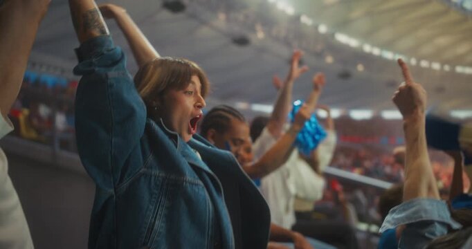 Diverse Soccer Fans Erupt in Championship Excitement Inside a Packed stadium Clapping, Waving Blue Pom-poms and Raising Arms as the Crowd Roars Through a Thrilling Match Atmosphere.