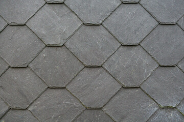 Obraz premium Close up of gray slate roof tiles arranged in a hexagonal pattern.