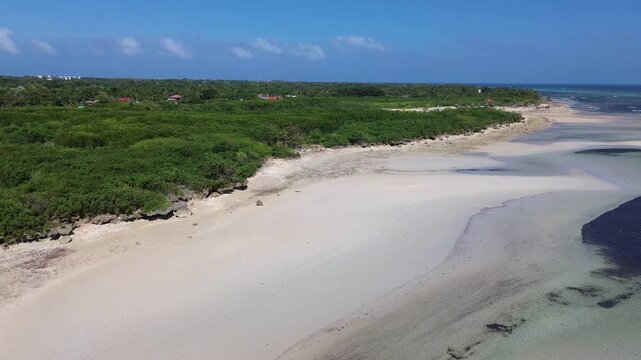 Cinematic drone view of a pristine white sandbank at low tide surrounded by crystal clear water and dense green tropical nature creating a serene and untouched coastal landscape, Philippines Bantayan
