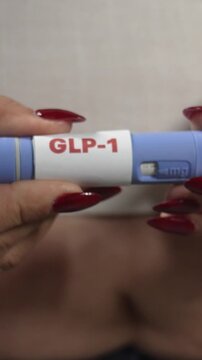 Overweight woman holding a GLP-1 injection pen at home, weight control and insulin resistance care