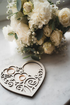newlyweds wedding rings on a wooden heart-shaped stand