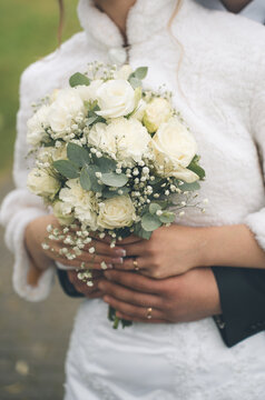 Couple's hands wearing engagement and wedding rings, symbolizing love, commitment, and marriage. A close-up view of joining hands