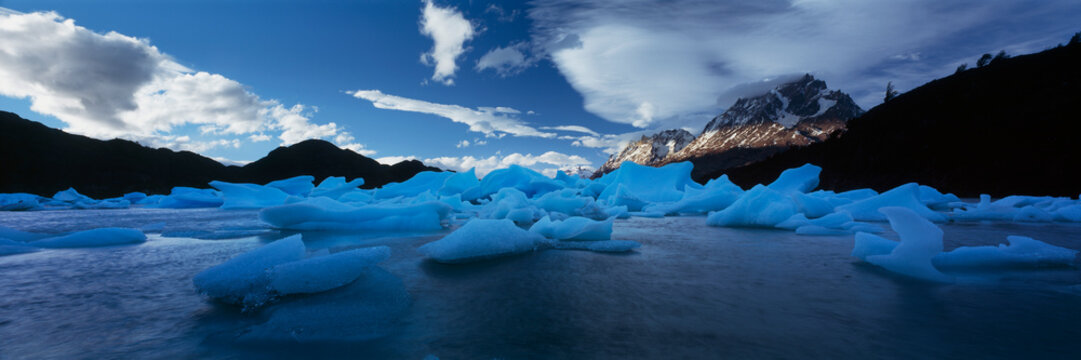 Scenic, panoramic view of blue Ice formations on Lago Grey below mountains, Patagonia, Chile
