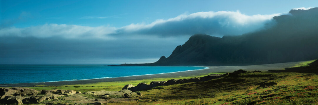 Scenic, panoramic view of tranquil ocean beach and green shore, Iceland
