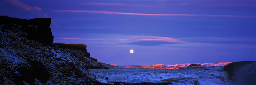 Panoramic view of Gullfoss waterfall under full moon in night sky, Iceland
