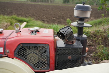 Fototapeta premium Red Mini Tractor with Engine Components in Field