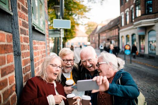 Senior friends taking a selfie on old town street
