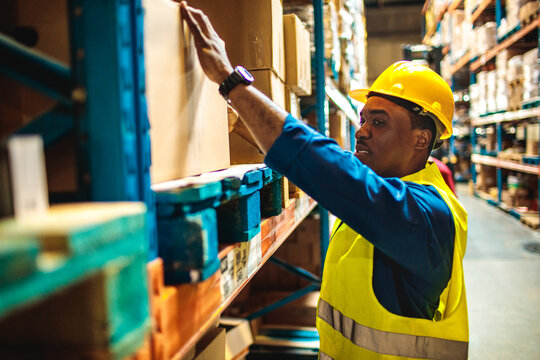 Warehouse worker organizing boxes on storage shelves
