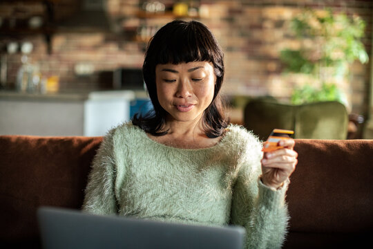 Woman shopping online with credit card at home