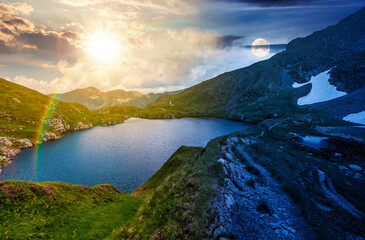 Fototapeta premium gorgeous summer solstice on capra lake. day meet night. sun and moon over breathtaking view of transylvaia alps in romania. composite background image for astrology wallpaper concept