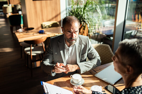 Mature business colleagues discussing documents at cafe