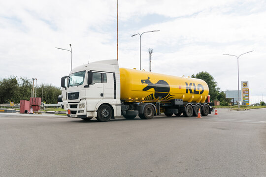 MAN truck with yellow fuel tank semi-trailer and KLO logo parked at gas station
