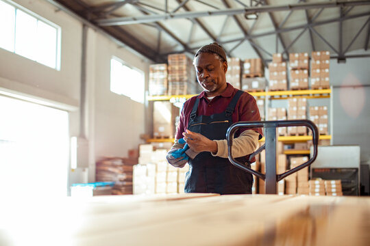 Warehouse worker putting on gloves in distribution center