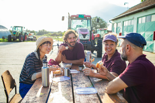 Farm workers sharing lunch break at rural tractor yard