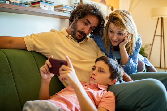 Parents watching their son on a smartphone at home