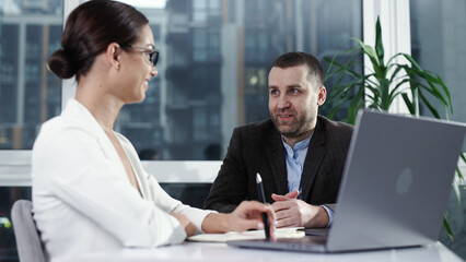 Fototapeta premium Businesswoman entrepreneur conducting job interview with male candidate in modern office. Recruitment and hiring concept.