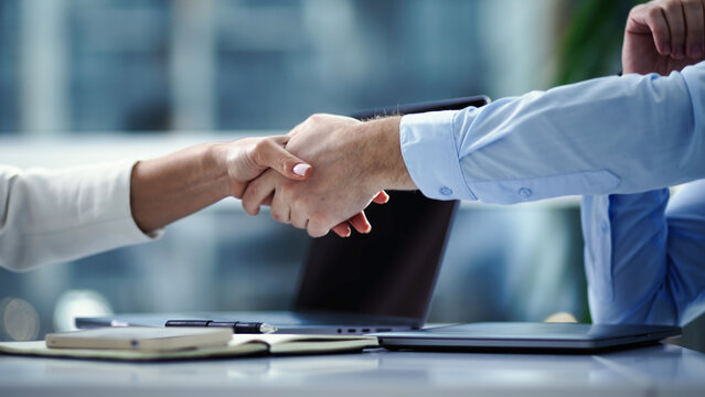 Business people shaking hands in modern office. Partnership and agreement concept.
