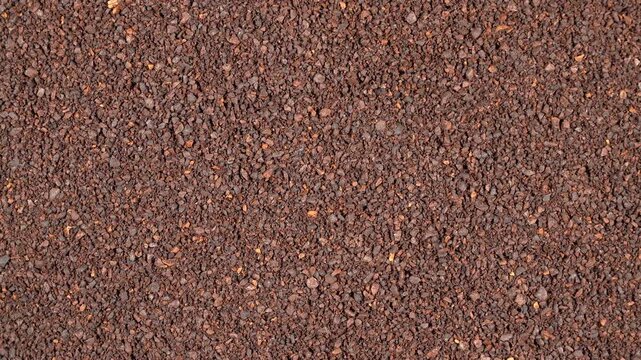 Top-down rotating background of rich ground coffee powder. Premium roasted dark brown texture for cinematic cafe and barista video projects.