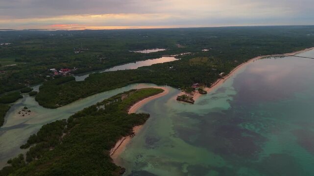Wide drone shot of the remote natural beauty of Bantayan Island, Philippines. A peaceful evening scene showing the vastness of the archipelago and its pristine coastal environment