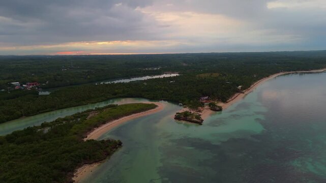 Panoramic aerial perspective of Bantayan Island, Philippines, at dusk. Capturing the soft reflections of the sunset on the water and the quiet atmosphere of the tropical coastline