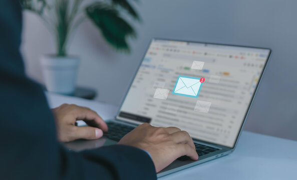 businessman checking email notifications on a smartphone represents digital communication, laptop messaging, and efficient information management in a modern technology-driven workplace.