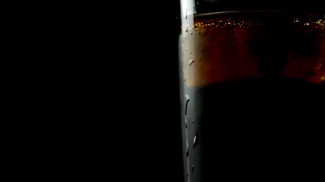 Ice cubes floating in a glass of whiskey, close-up view, alcohol, space for text