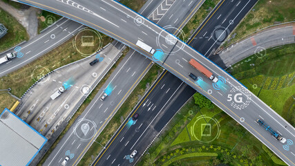 Aerial view of modern highway interchange with autonomous vehicles and connectivity symbols. Smart traffic systems and 5G technology for future transportation and intelligent mobility solutions. © Fahroni