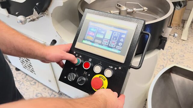 Professional Over the Shoulder Shot of Roaster Operator Hand Adjusting Digital Control Panel Screen During Coffee Roasting Cycle in Industrial Specialty Production Factory Facility Environment