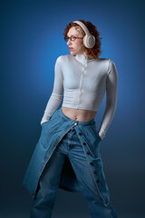 Young woman with red curly hair enjoys music in a modern studio setting