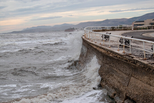 Powerful sea wave splashing against a stone sea wall