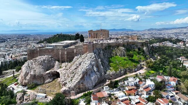 Aerial drone cinematic video of iconic Acropolis hill and the Parthenon a true ancient monument of Western Civilization with beautiful clouds, Athens historic center, Attica, Greece