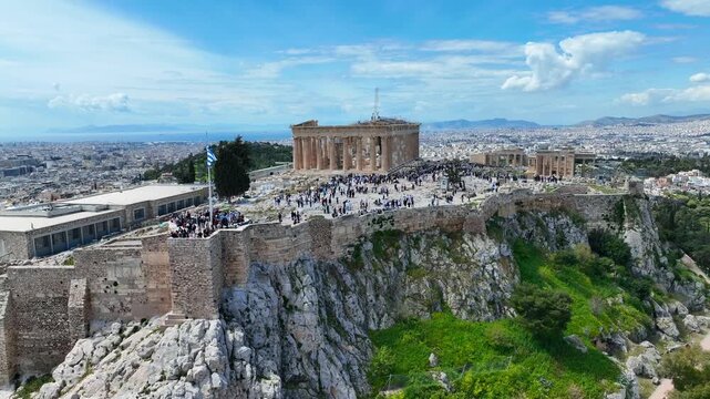 Aerial drone cinematic video of iconic Acropolis hill and the Parthenon a true ancient monument of Western Civilization with beautiful clouds, Athens historic center, Attica, Greece