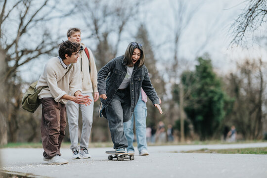 A group of teenagers skateboarding while friends cheer and encourage from the path. Casual outdoor scene of young people enjoying time together in a park.