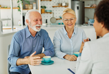 Obraz premium Senior couple having a meeting with an agent, businesswoman, salesperson or doctor in his office