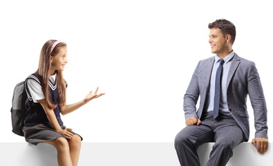 Obraz premium Schoolgirl and a man sitting on a blank panel and having a conversation