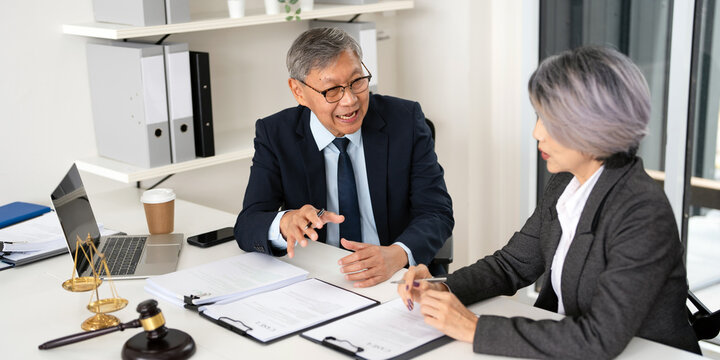 Lawyer, solicitor or barrister, supervisor talk to analyse case report, discussing paper policy terms conditions with client, conduct lawsuits document