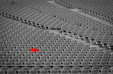 Fototapeta premium Outstanding empty red plastic seats in football stadium with rows of unoccupied chairs at outdoor soccer arena, reserved seating concept during match preparation. Sport venue infrastructure.