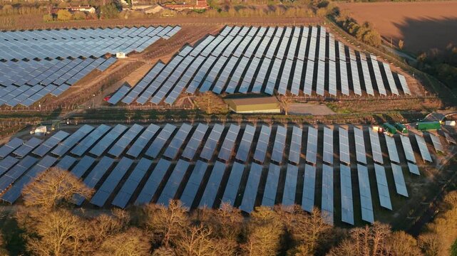 Aerial drone view of Tye Lane solar farm at golden sunset with renewable energy arrays in Suffolk UK