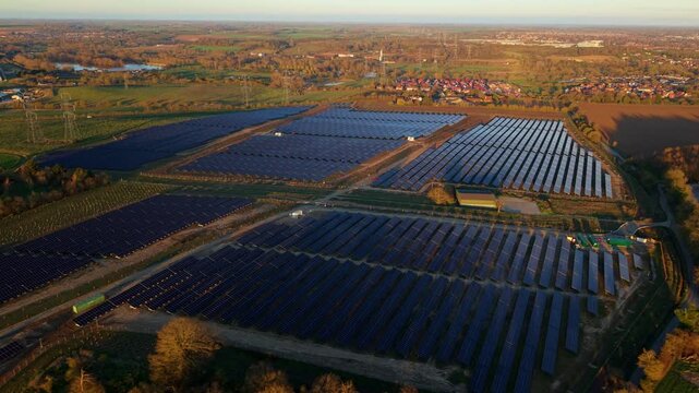 Aerial drone view of Tye Lane solar farm at golden sunset with renewable energy arrays in Suffolk UK