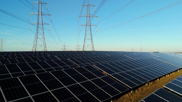 Aerial view of solar panel array and high voltage pylons in Tye, UK