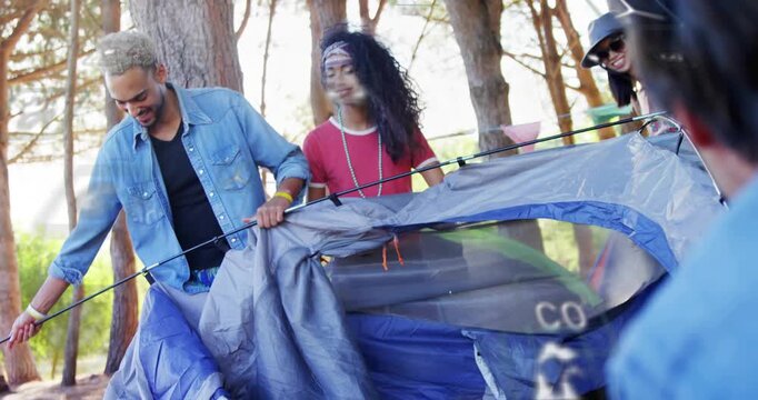 Five campers arriving at campsite and pitching dome tent, animated arrows guiding pole seating