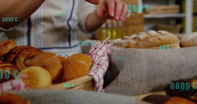 Baker reaching into basket, placing rolls and buns for bakery display while teal numbers floating